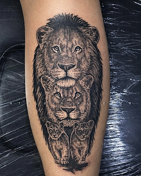 León, leona y dos cachorros en realismo negro y gris, tatuados en la pantorrilla