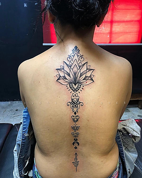 Flor de loto con ornamento que baja por la columna, en la espalda