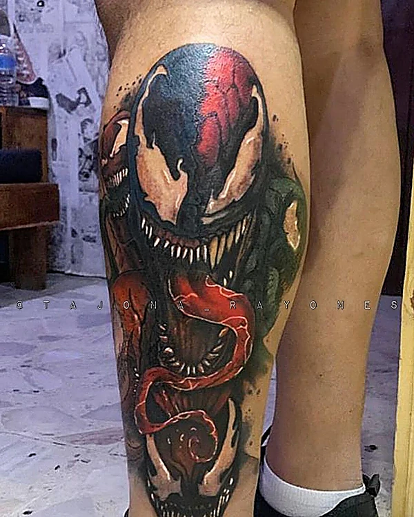 Venom a color en rojo y negro, tatuado en la pantorrilla